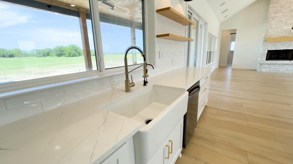 Farmhouse sink under a window in a custom home kitchen by 1802 Build Co.