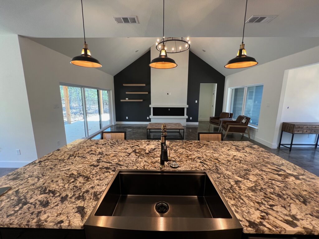 Granite kitchen island with pendant lights in a custom home by 1802 Build Co.