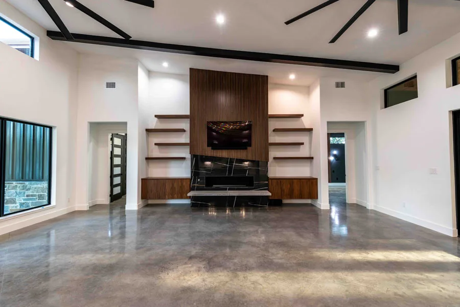 Open-concept living room with a fireplace wall in a home renovation by 1802 Build Co.